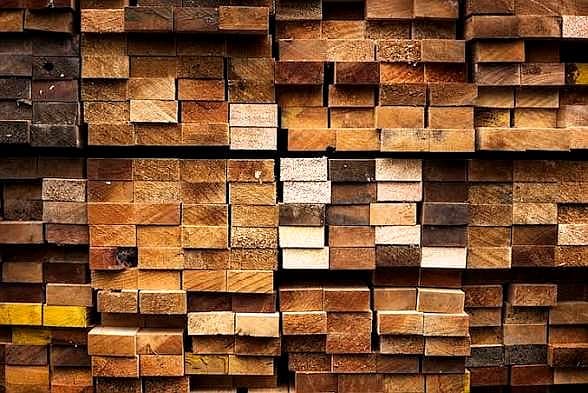 Structural timber beams and planks stacked for construction projects