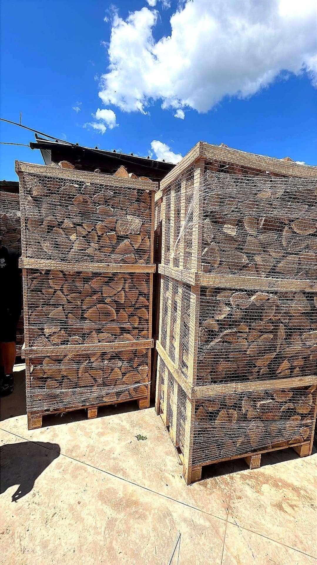 Firewood crates stacked and covered with netting for storage