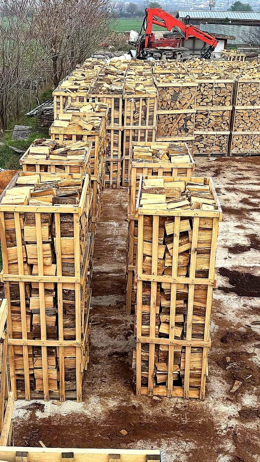 Firewood storage yard with machinery handling stacked logs